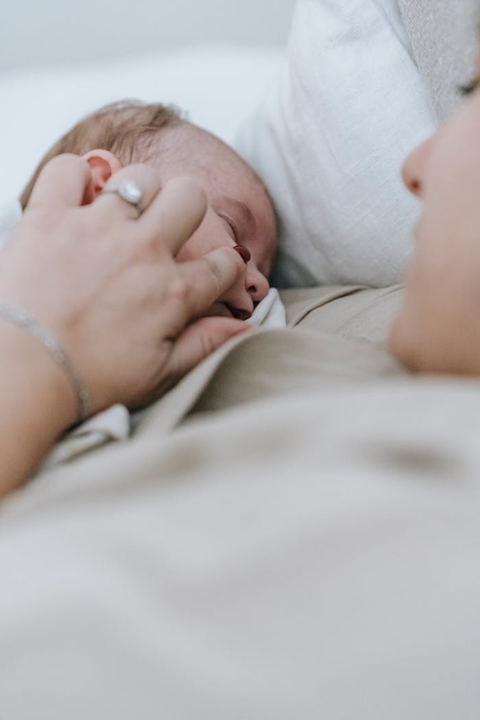 A serene scene of a baby asleep, comforted by a motherly touch, evoking warmth and tenderness.